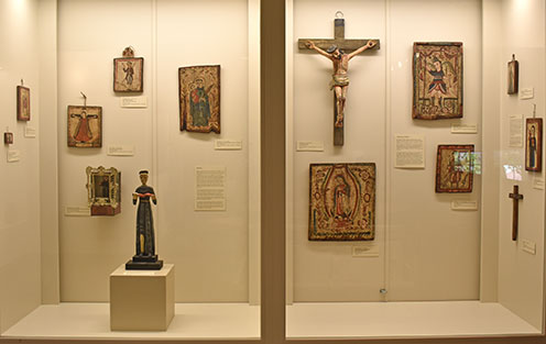 two display cases with santos and retablos from region mostly dating from 19 century