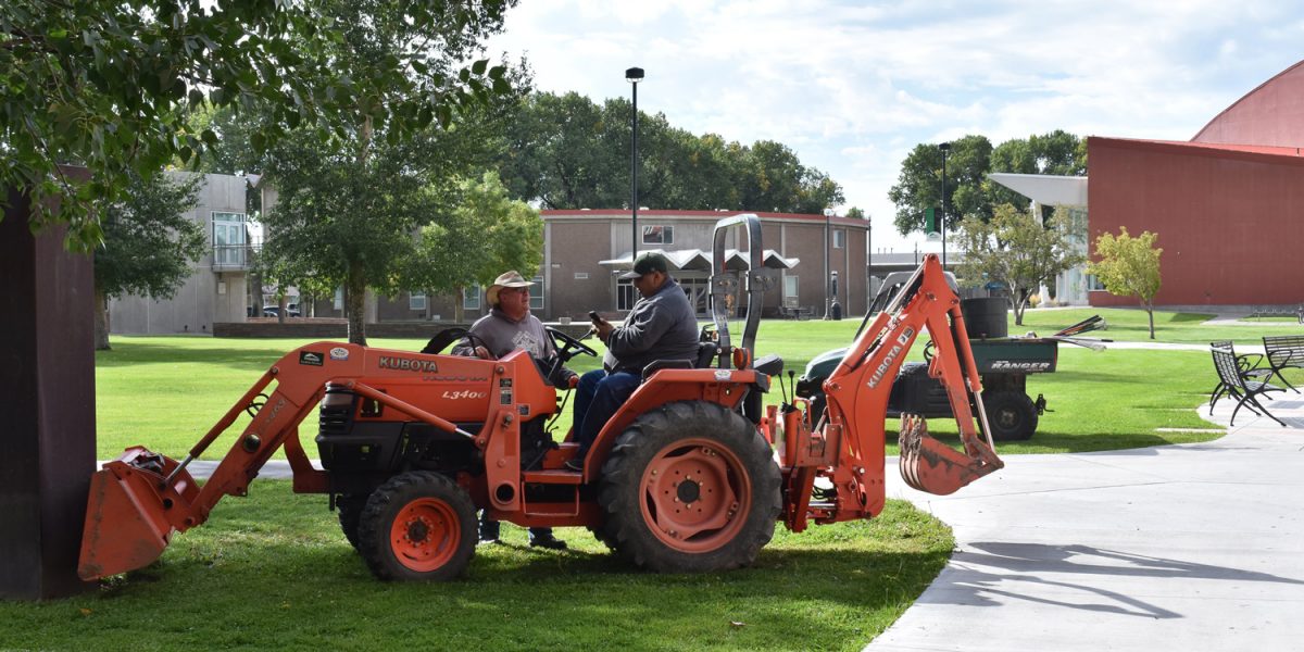 Adams State Facilities services working on tractor