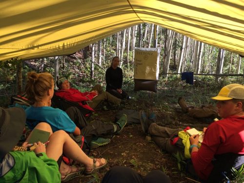 Adventure Program students sitting in a yellow tent in the mountains