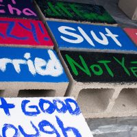 cinder blocks painted with oppressive words or phrases