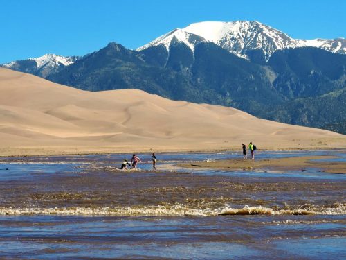Family playing in Medano Creek at Great Sand Dunes National Park