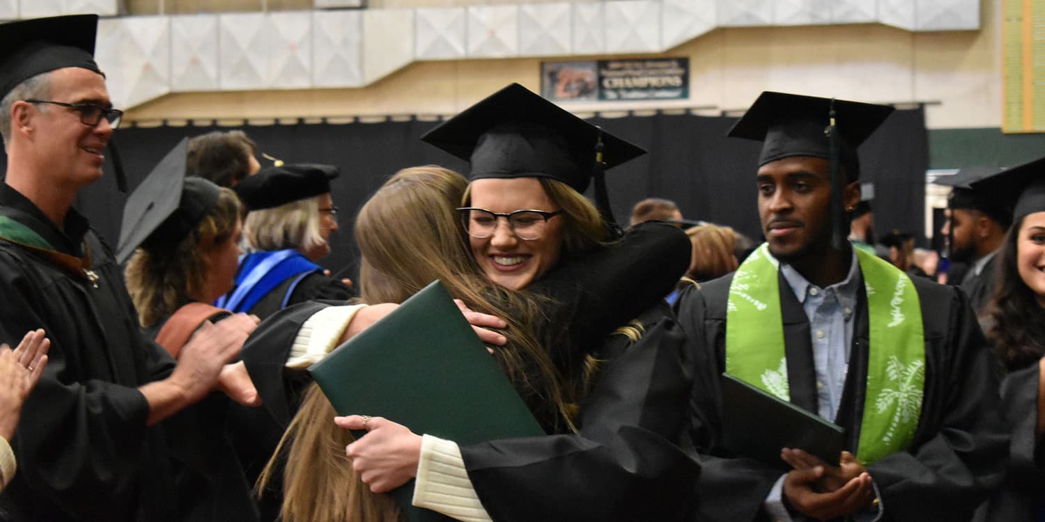 graduate hugs family member at Adams State Fall 2019 Commencement