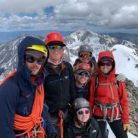 Outdoor Education and Stewardship students standing on a summit during a mountaineering course