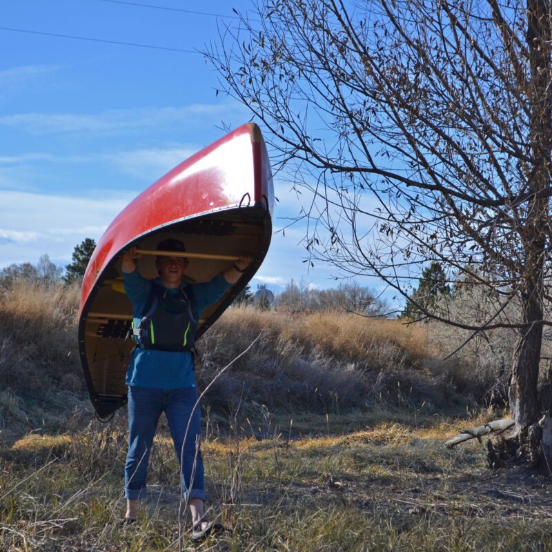 student carrying a canoe