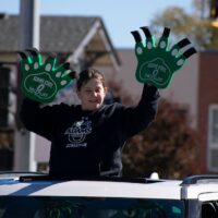 Adams State homecoming parade participant waves ultra large hands