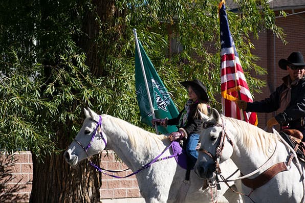 Horseriders carry flag in 2021 Adams State Homecoming parade