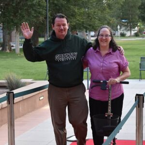 two people waving while on campus
