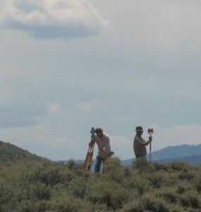 Two Cultural Resource Managers work with equipment in the field