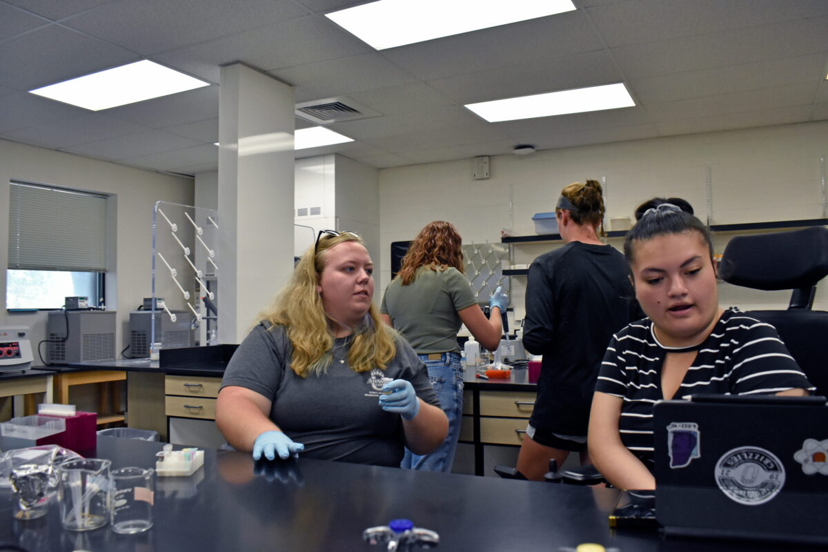 Students work in a cellular biology lab on the Adams State campus in a decorative picture.