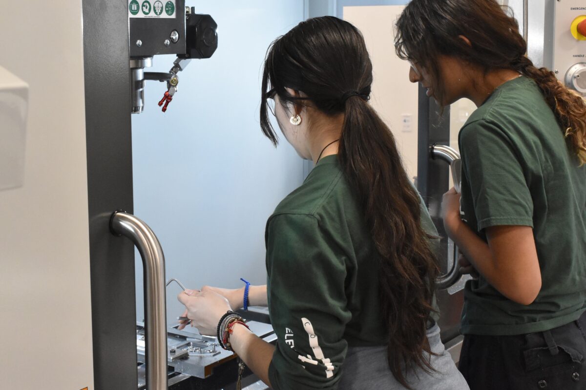Two students work using a piece of equipment in the Mechanical Engineering lab.