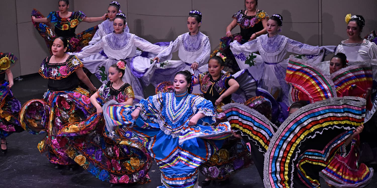 Adams State University Semillas de la Tierra Dance Group performing on Richardson Hall Auditorium stage