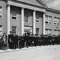 Adams State University 1930 Commencement graduates lined up outside of Richardson Hall