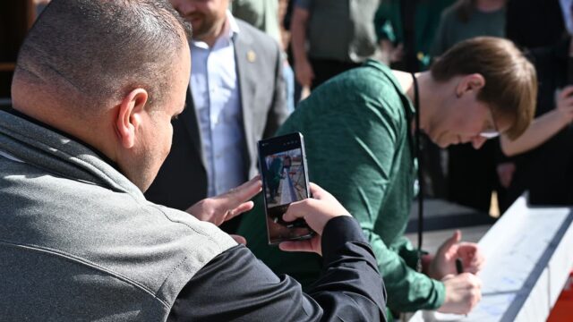 Adams State University Computing Services Building Beam Topping Ceremony, Dr. Savala DeVoge signing beam, Dr. Florencio Urias Aranda taking a video