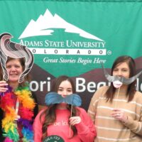 Adams State University Extended Studies honors san luis valley school counselors at luncheon pictured several counselors pose with funny props in front of backdrop