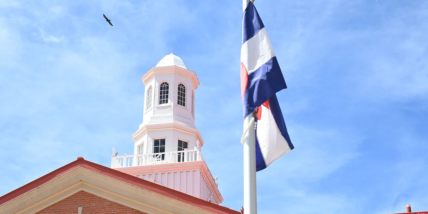 Adams State University Richardson Hall cupola with Colorado flag and soaring bird