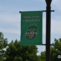 Adams State University Banner on Flag Pole Home of the Grizzlies