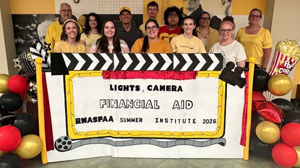 Rocky Mountain Association of Student Financial Aid Administrators (RMASFAA) Institute group photo of participants behind banner