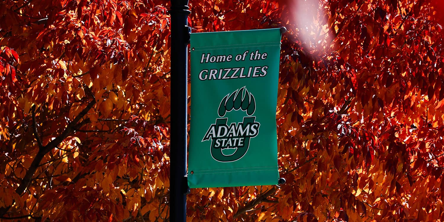 Adams State University campus autumn leaves and banner home of the grizzlies
